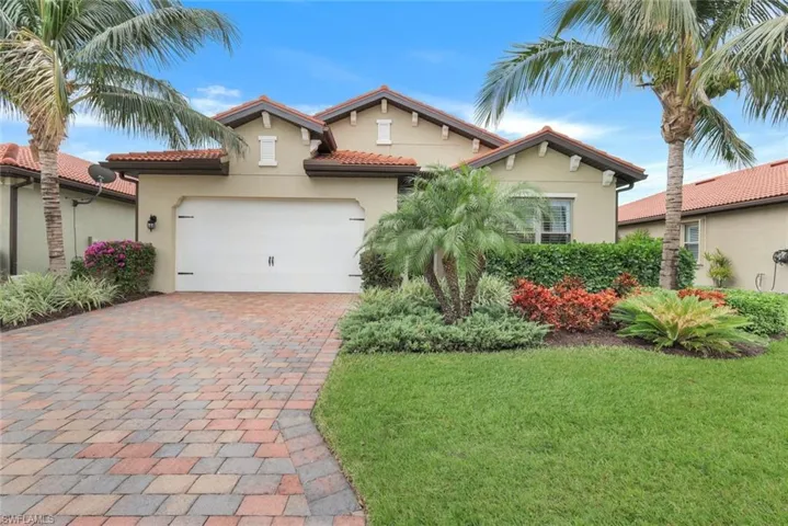 Mediterranean / spanish house with a front yard and a garage