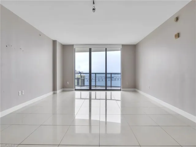 Spare room with a wall of windows and light tile patterned floors