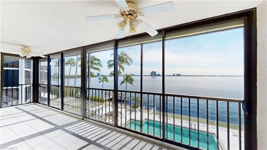 Unfurnished sunroom featuring a water view, expansive windows, and tile patterned floors