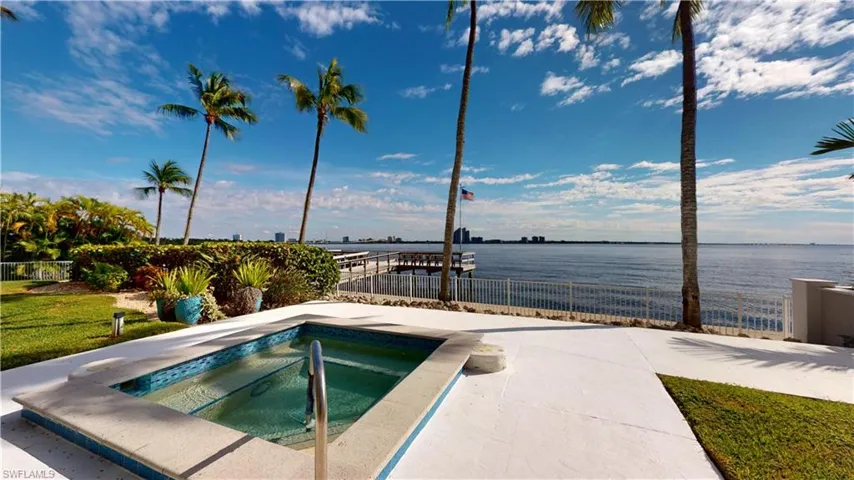 View of swimming pool featuring a water view, an in-ground hot tub, and a patio