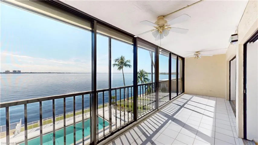 Unfurnished sunroom featuring a wall of windows, a water view, and tile patterned floors