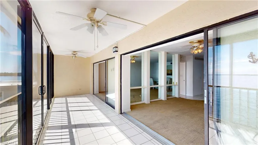 Unfurnished sunroom featuring ceiling fan