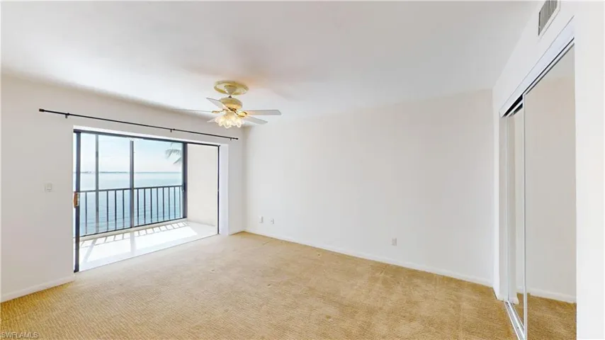 Unfurnished bedroom with light colored carpet, a closet, ceiling fan, and access to outside