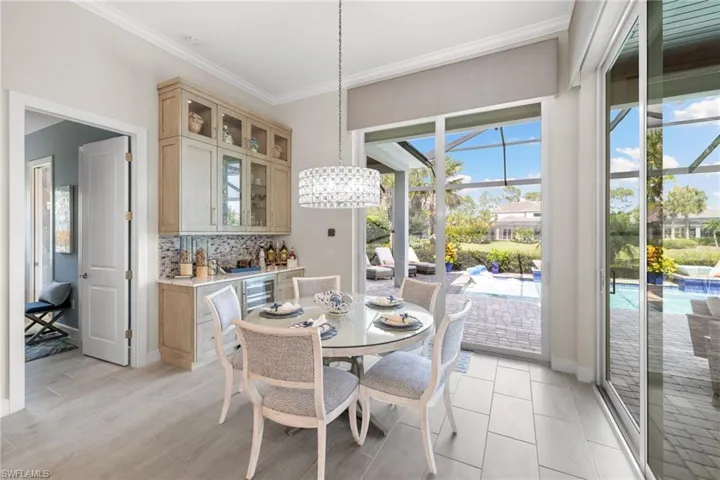 Dining space with a notable chandelier, crown molding, and wine cooler
