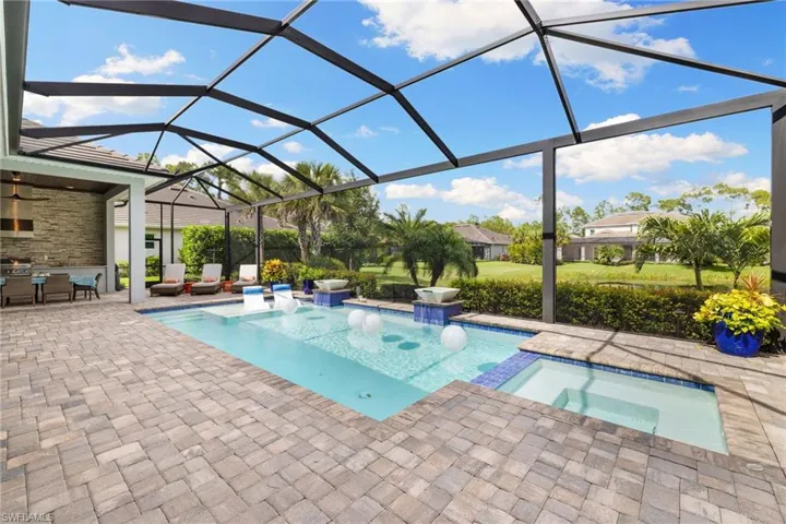 View of swimming pool with outdoor lounge area, a patio, glass enclosure, and an in ground hot tub