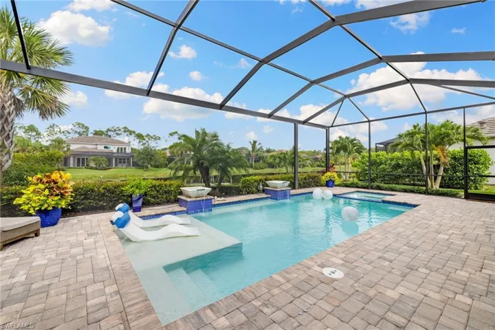 View of swimming pool featuring a patio and glass enclosure