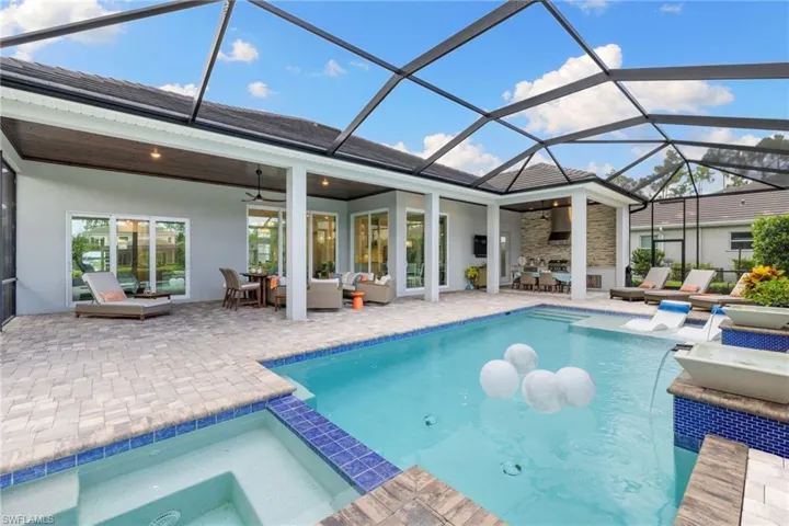 View of swimming pool with a lanai, an in ground hot tub, a patio area, ceiling fan, and an outdoor hangout area