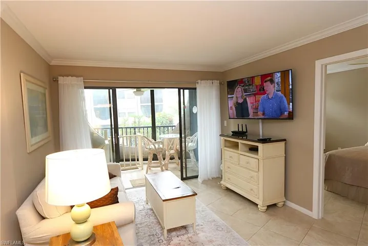 Living area featuring crown molding and light tile patterned floors