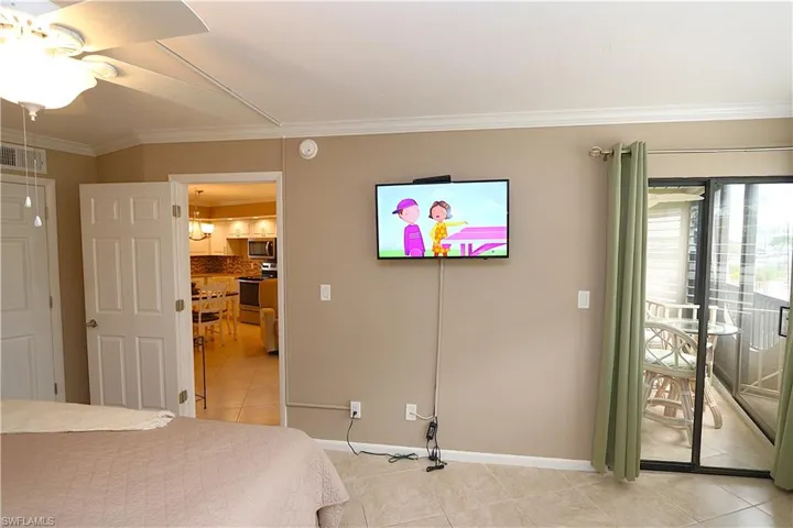 Bedroom featuring light tile patterned floors, crown molding, access to outside, and ceiling fan