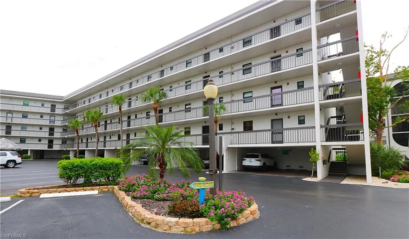 View of apartment building / complex featuring uncovered parking