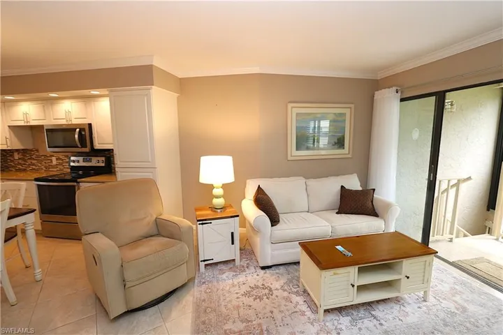 Living room featuring ornamental molding and light tile patterned floors