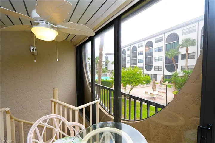 Balcony featuring a sunroom and view of pool area