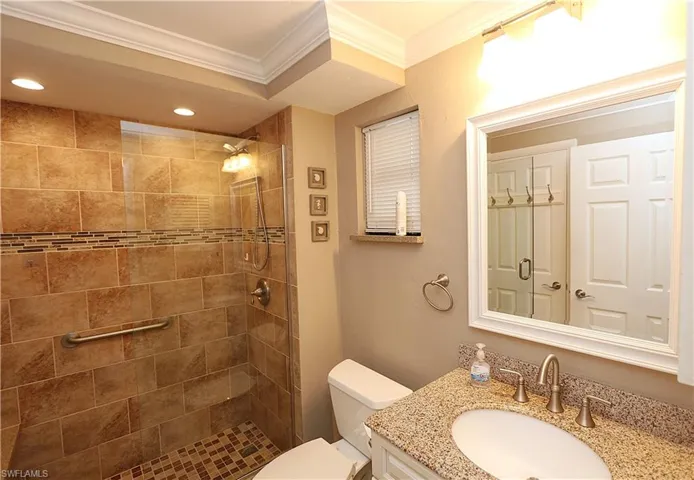 Bathroom with vanity, a stall shower, ornamental molding, and recessed lighting