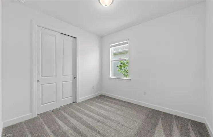 Unfurnished bedroom with a closet and carpet flooring