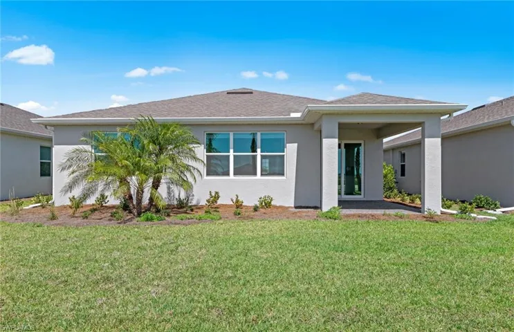 Back of property featuring a lawn
