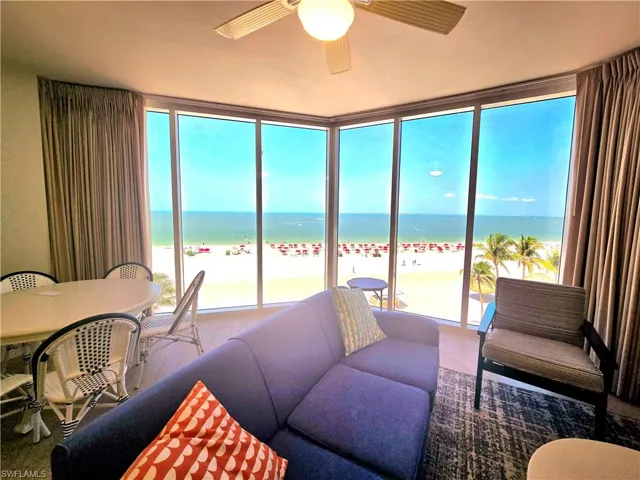 Living area featuring ceiling fan, a beach view, wood vinyl finished floors, and a water view