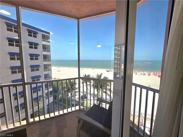 Balcony featuring a beach view and a water view