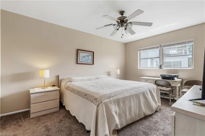 Bedroom with dark carpet, baseboards, and ceiling fan