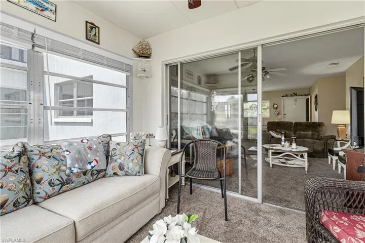 Living room with carpet floors, ceiling fan, and french doors