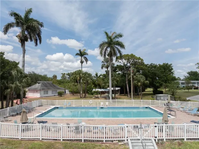 Community pool featuring fence and a patio area
