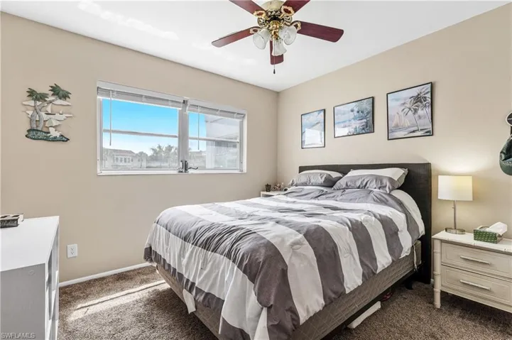 Bedroom with dark carpet, baseboards, and ceiling fan