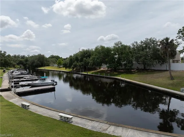 Dock area with a water view and a lawn
