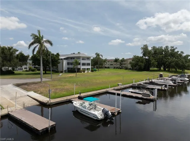 Dock area with a water view and a lawn