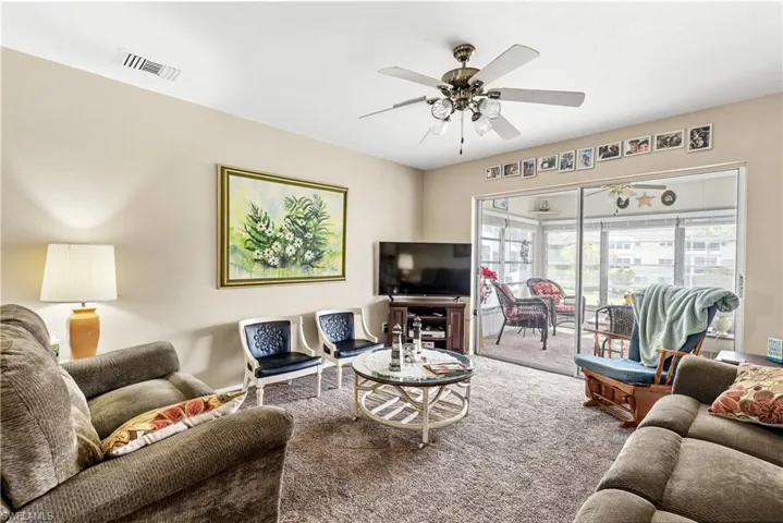 Living area with carpet and ceiling fan