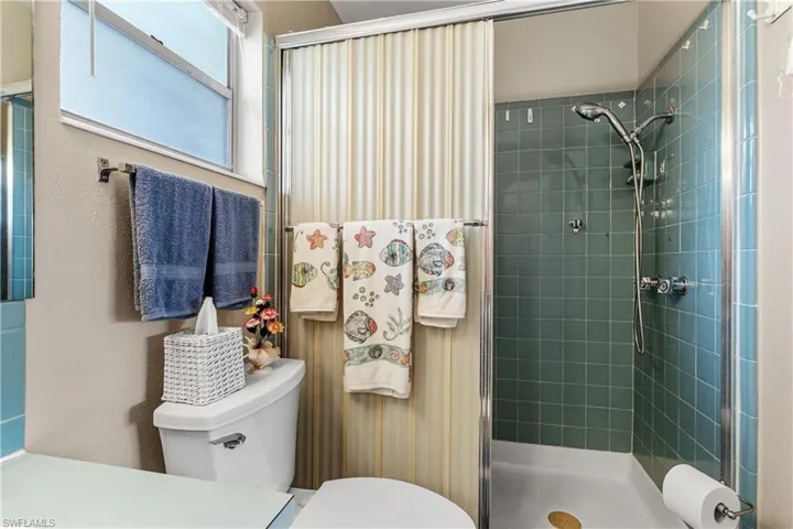 Full bathroom with toilet and a shower stall