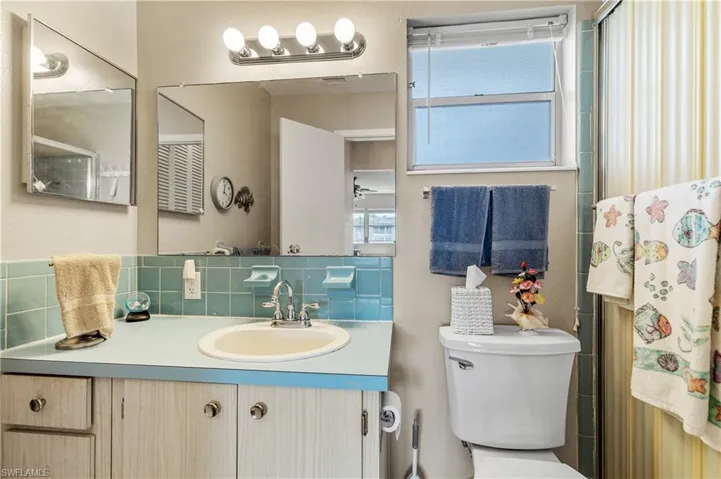 Bathroom with toilet, tasteful backsplash, vanity, and a shower