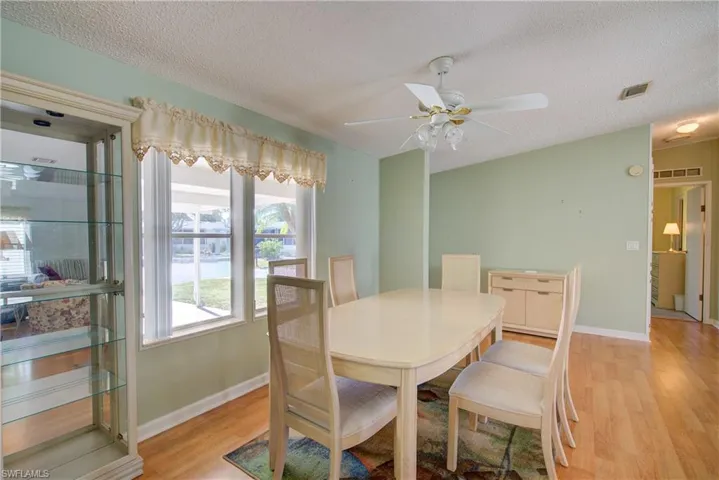 Dining space with light wood finished floors, a textured ceiling, and a ceiling fan