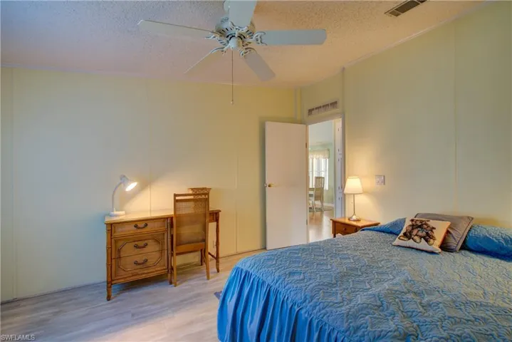 Bedroom with wood finished floors, a textured ceiling, and ceiling fan