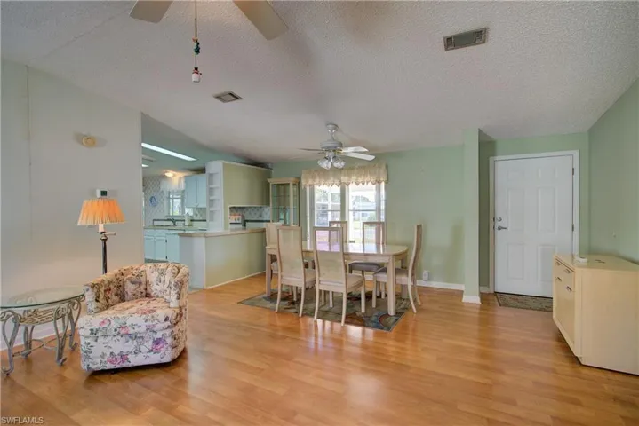 Dining room with light wood-style flooring, a textured ceiling, and ceiling fan