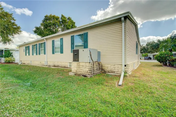 Back of property featuring a lawn and crawl space