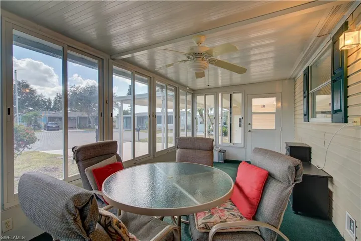 Sunroom featuring healthy amount of natural light, a ceiling fan, and outdoor dining space