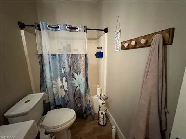 Bathroom with shower / tub combo and toilet