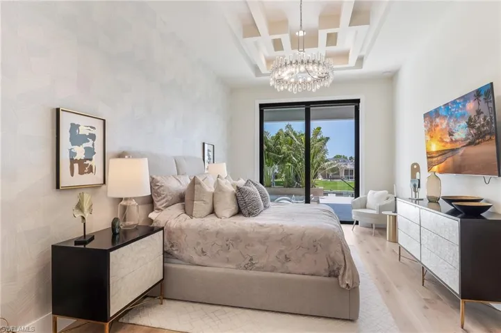 Bedroom featuring coffered ceiling, access to outside, light wood-type flooring, a chandelier, and beamed ceiling
