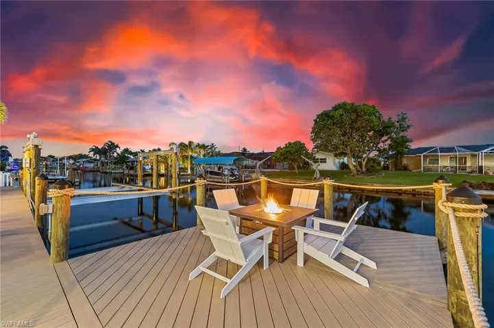 Dock area with a water view, an outdoor fire pit, and boat lift
