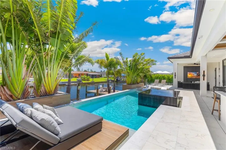 Swimming pool featuring ceiling fan, a water view, a patio area, and outdoor lounge area