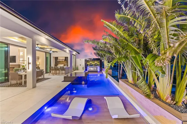 Swimming pool with a ceiling fan, a patio area, a jacuzzi, and an outdoor hangout area
