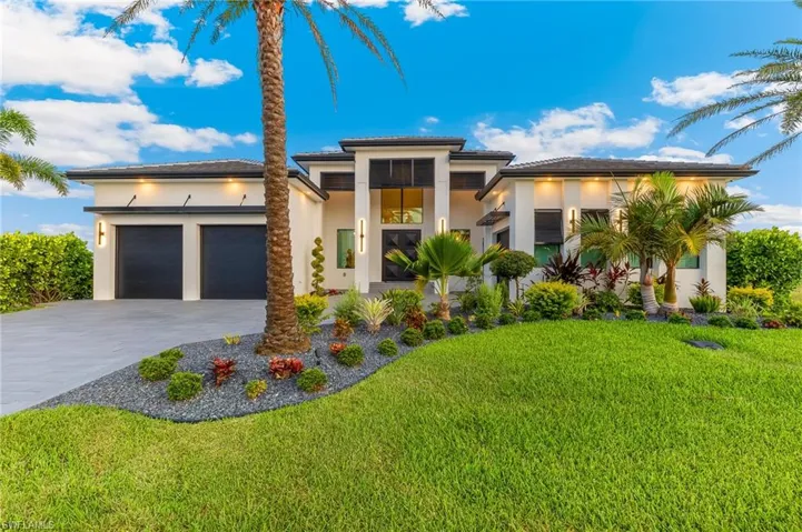 Prairie-style house featuring concrete driveway, a garage, stucco siding, and a front lawn
