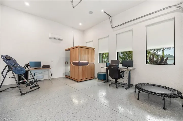 Toy Garage, additional Office space featuring speckle patterned floor, a wall mounted AC, plenty of natural light, and recessed lighting