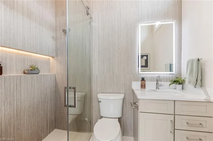 Full bathroom with toilet, vanity, and a shower stall
