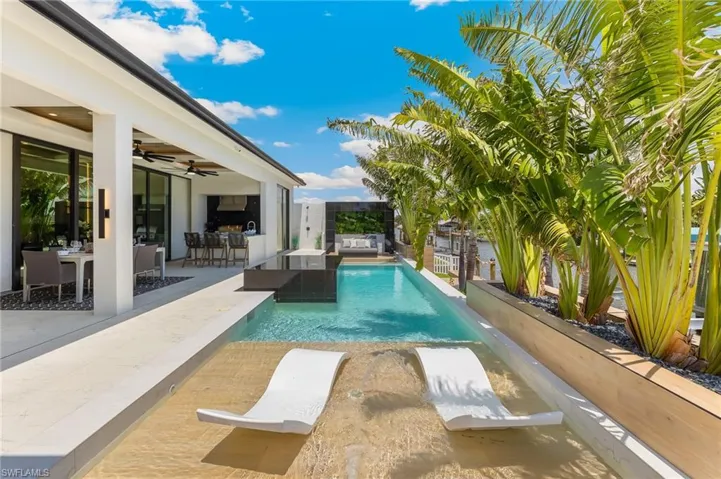 Outdoor pool with a ceiling fan, outdoor lounge area, a fenced backyard, and a patio area