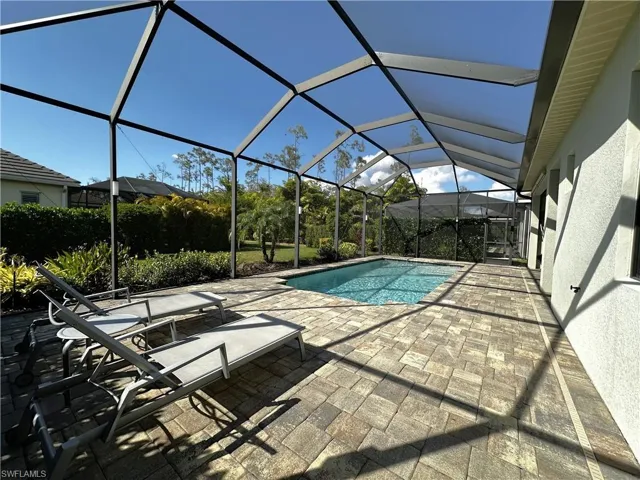 View of swimming pool with a lanai and a patio area