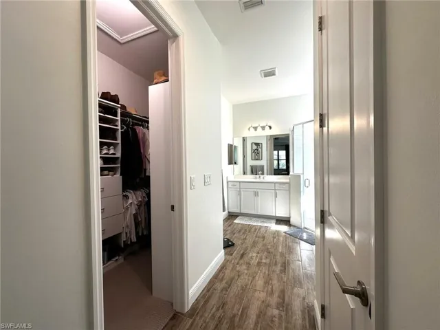 Hall featuring wood-look tile flooring and built-in closets