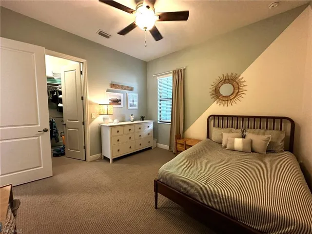 Bedroom featuring ceiling fan, a built-in closet, and carpet floors