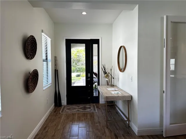 Foyer with baseboards, wood-look tile flooring, and recessed lighting