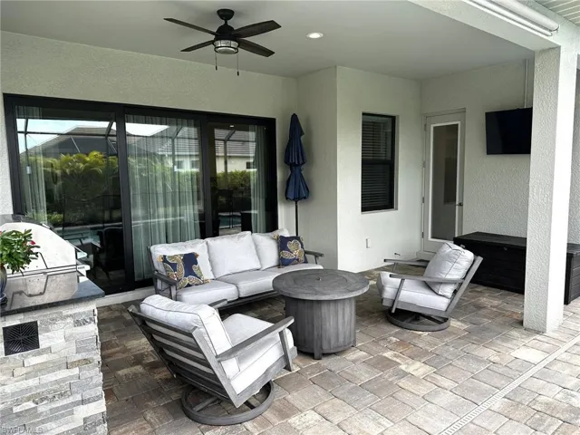 View of patio with ceiling fan and an outdoor living space