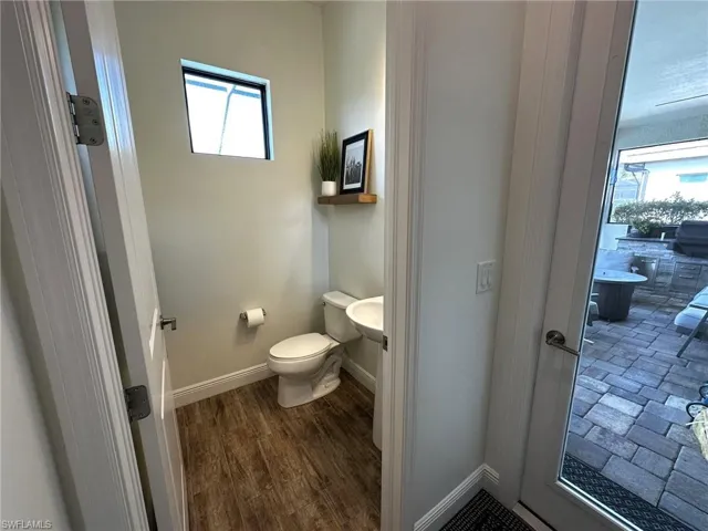 Pool half-bathroom with wood-look tile, a wealth of natural light, and toilet
